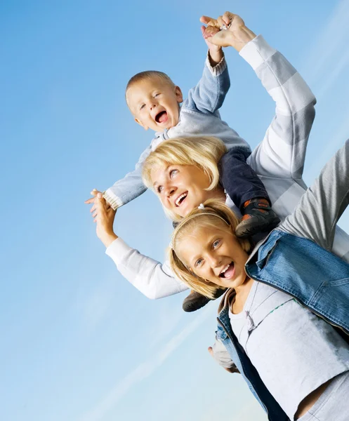 Здоровая семья на открытом воздухе. Счастливая мать с детьми над голубым небом — стоковое фото