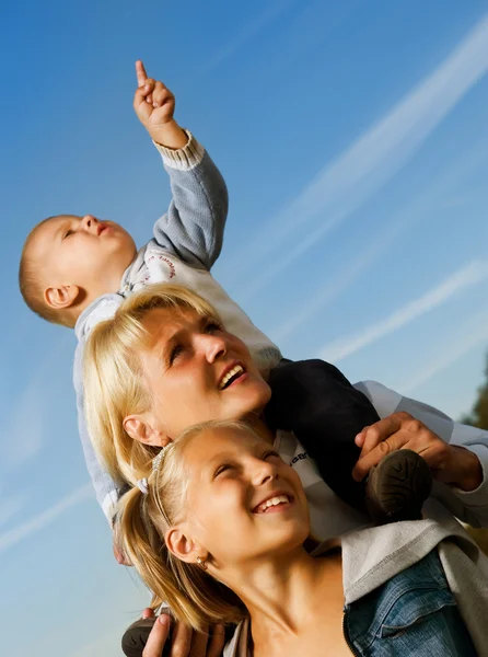 Здоровая семья на открытом воздухе. Счастливая мать с детьми над голубым небом — стоковое фото