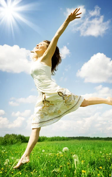 Mutlu genç kadın üzerinde mavi gökyüzü atlama Telifsiz Stok Fotoğraflar