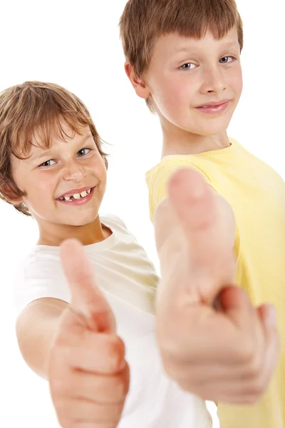 Два маленьких мальчика указывают на белый знак ОК — стоковое фото