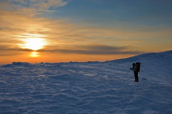 Trekker-Silhouette bei Sonnenuntergang in den Bergen — Stockfoto