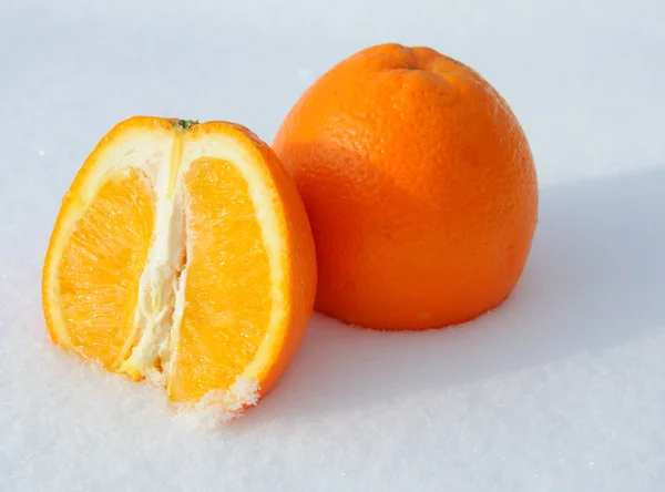 Primo piano di pezzi di taglio arancione nella neve bianca — Foto Stock