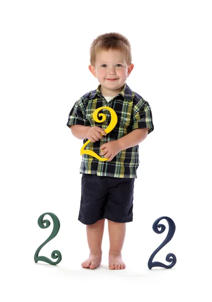En toårig holder en nummer to - Stock-foto