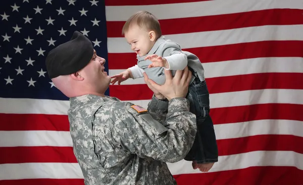 アメリカの兵士は彼の幼い息子を保持します。 ロイヤリティフリーのストック画像