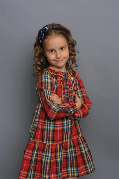 Klein meisje in geruite jurk — Stockfoto