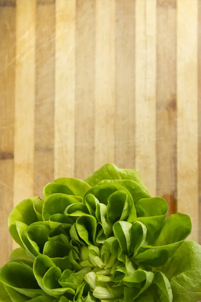 stock image EDZR - Crop of a fresh lettuce on a wood table