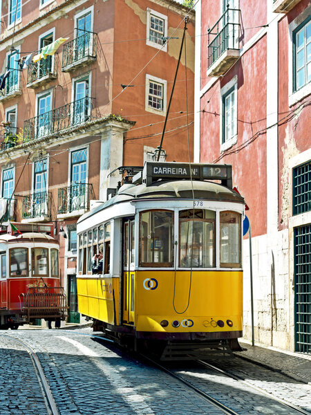 Traditional yellow and red trams downtown Lisbon. Trams are used
