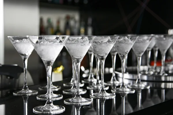 Cuplu așezat la bar, sticlă de cocktail în prim plan — Fotografie, imagine de stoc