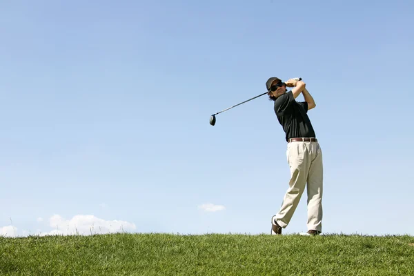 Golfer schieten een golfbal Stockafbeelding