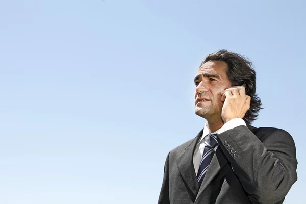 stock image Businessman answering a call while his colleagues having a discu