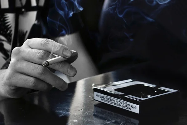 Muž drží v ruce cigaretu — Stock fotografie
