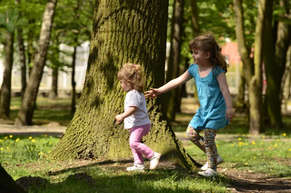 Two little girls at play in the park — Stock Photo, Image