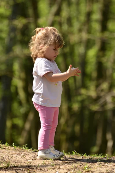 Pikkutyttö löysi linnun höyheniä — kuvapankkivalokuva