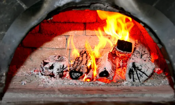 stock image Flaming wood in old home brick fireplace