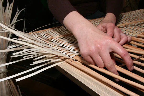 stock image Female hands manually mastering wicker fabric