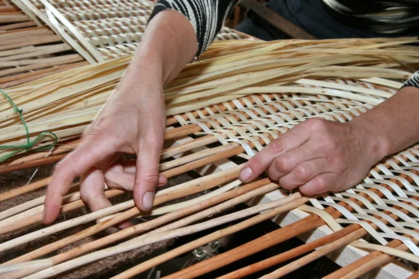 Mãos femininas dominando manualmente tecido de vime — Fotografia de Stock