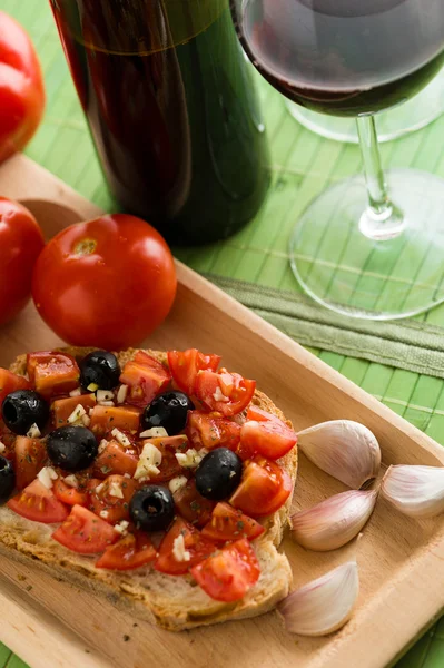 Bruschetta com tomates e azeitonas pretas — Fotografia de Stock