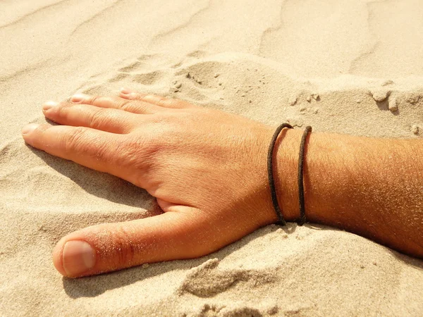 Mão na brincadeira com a areia em uma praia — Fotografia de Stock