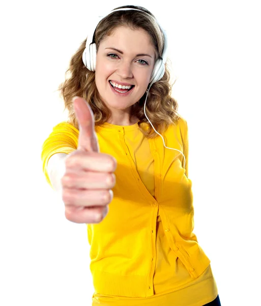 Thumbs-up woman enjoying music — Stock Photo, Image