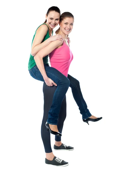 Teenage girl piggybacks her friend — Stock Photo, Image