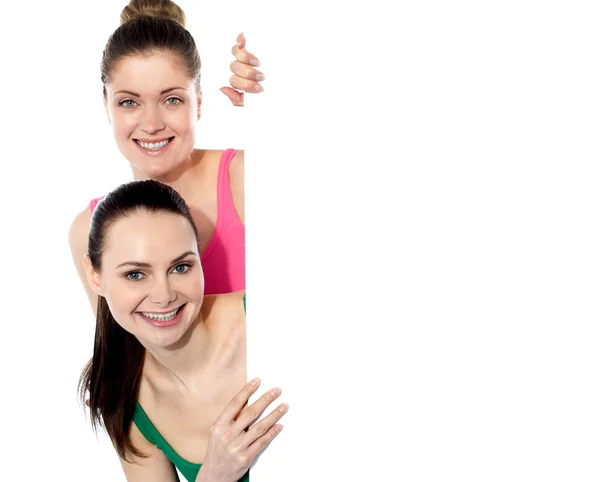 Dos chicas atractivas sosteniendo pizarra en blanco —  Fotos de Stock