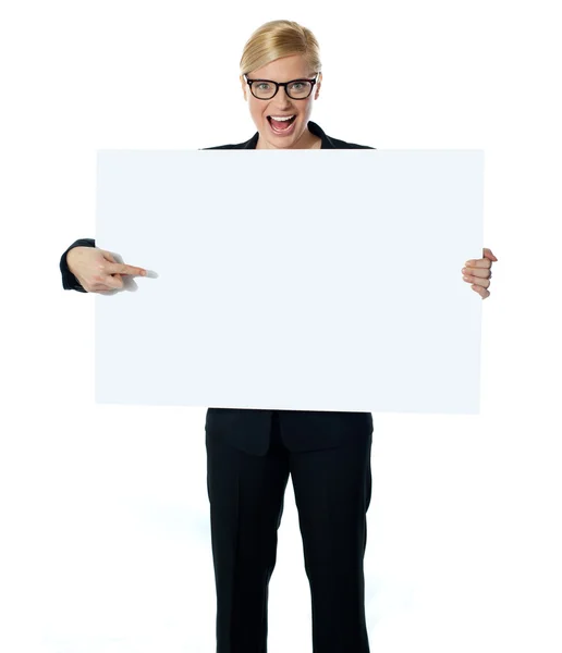 Verkäuferin zeigt auf leere Plakatwand — Stockfoto