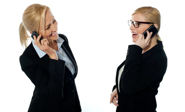 Empresárias que se comunicam através de telefones celulares — Fotografia de Stock