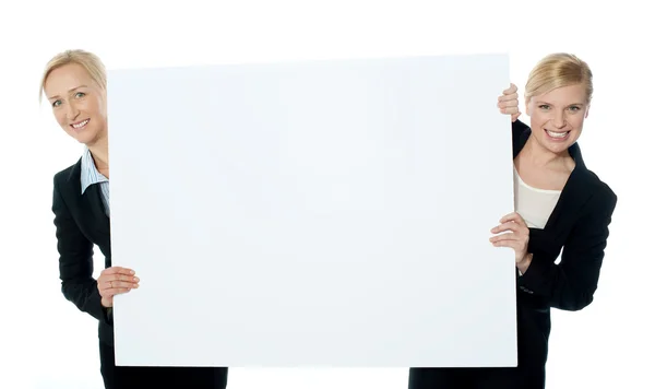 Representantes do sexo feminino apresentando banner anúncio em branco — Fotografia de Stock