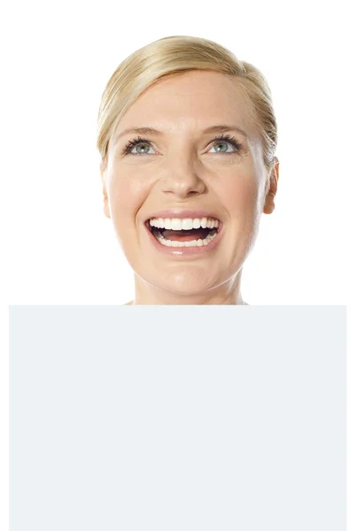 Thoughtful smiling woman holding whiteboard — Stock Photo, Image