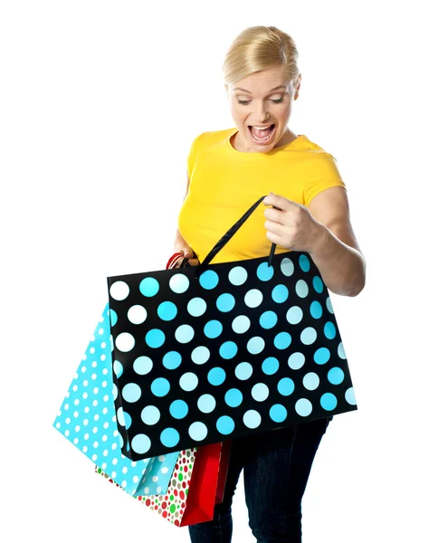 Menina olhando entusiasmado dentro de seu saco de compras — Fotografia de Stock