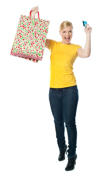 Adolescente animado segurando saco de compras e cartão — Fotografia de Stock