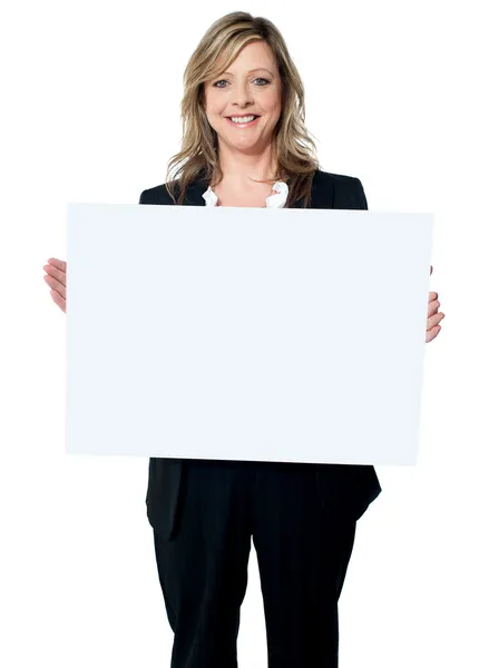 Smiling woman holding a blank billboard — Stock Photo, Image