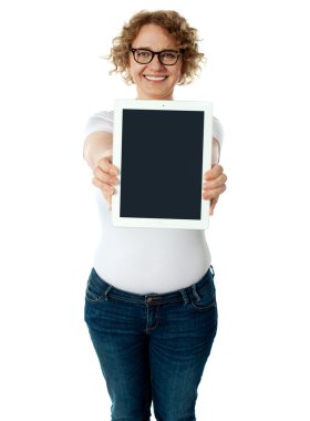 Woman showing tablet screen to camera clipart