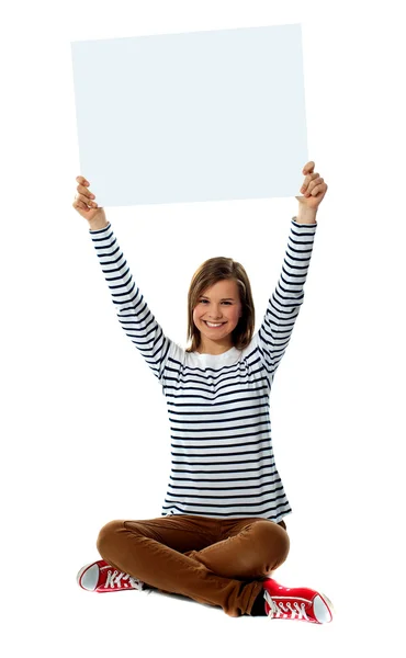 Девушка держит чистый рекламный щит в направлении вверх — стоковое фото