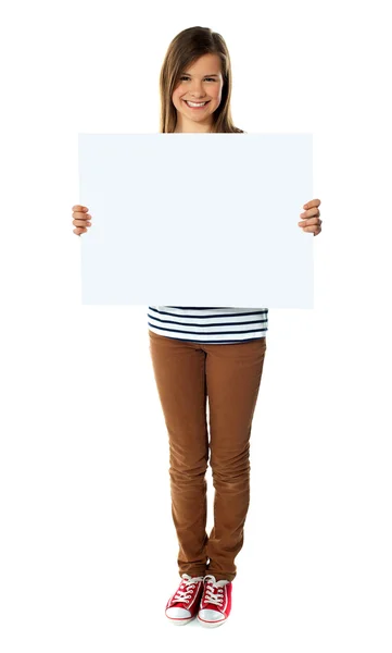 Chica sonriente sosteniendo tablero blanco vacío — Foto de Stock
