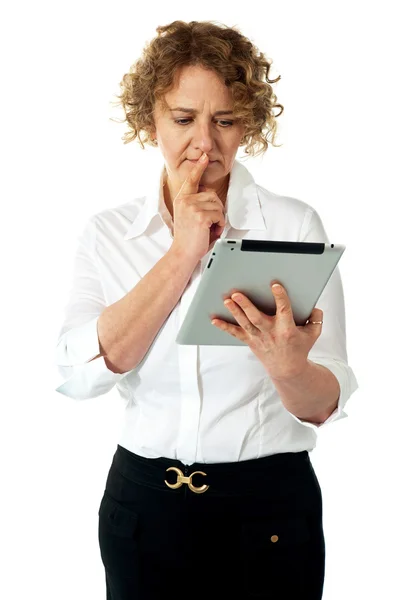 Geschäftsfrau schaut aufs Tablet und denkt tief nach — Stockfoto