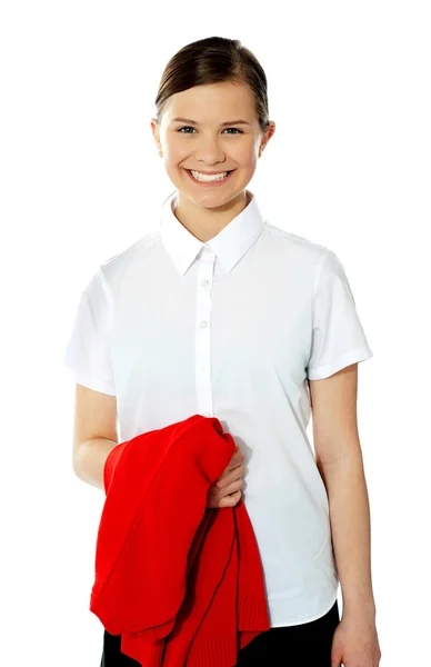 Escola menina segurando sua camisola vermelha e sorrindo — Fotografia de Stock