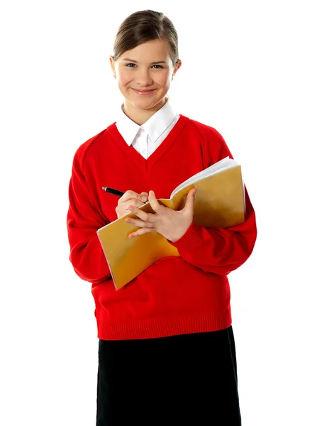 Estudante caucasiano menina da escola escrevendo em seu caderno — Fotografia de Stock