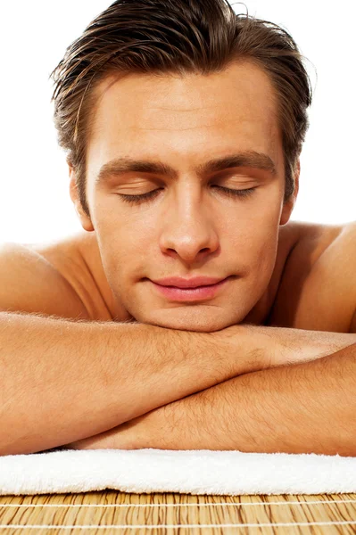 Homme attrayant reposant avec les yeux fermés au spa — Photo
