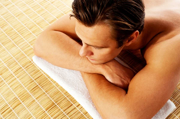 Man relaxing in a spa resort on mat — Stock Photo, Image