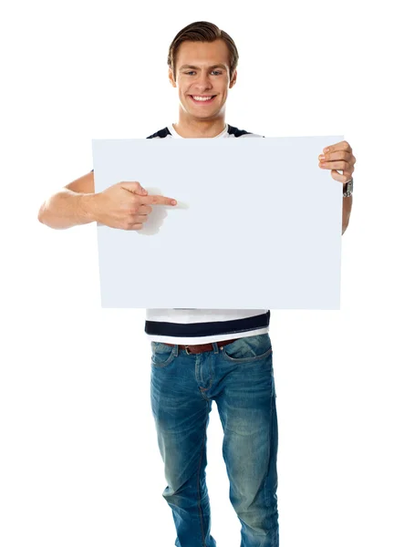 Retrato de um jovem apontando para uma placa em branco — Fotografia de Stock