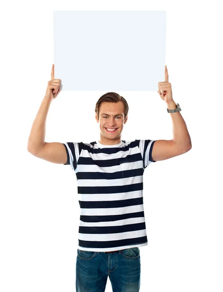 Молодой человек показывает билборад над головой — стоковое фото