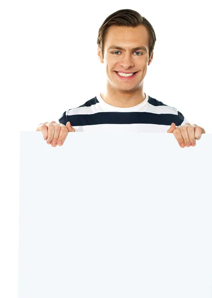 Casual jovem segurando um cartaz em branco — Fotografia de Stock
