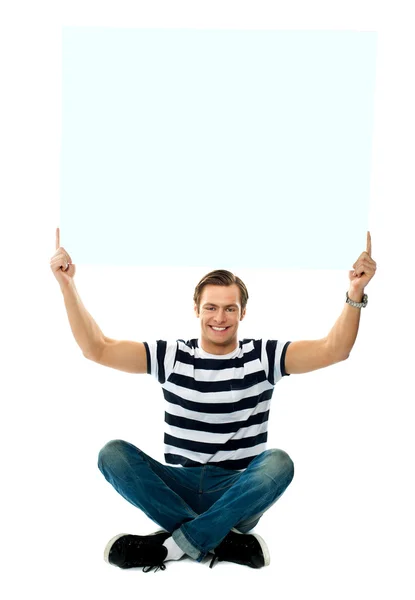 Homem sentado mostrando tabuleta em branco — Fotografia de Stock