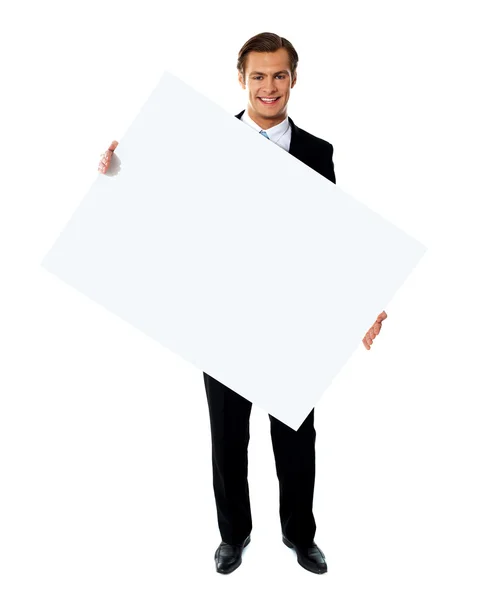 Young corporate male holding tilted blank billboard — Stock Photo, Image