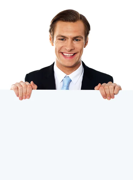 Cool businessman holding a blank poster — Stock Photo, Image