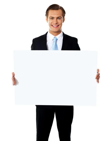 Joven empresario sosteniendo cartelera blanca en blanco — Foto de Stock