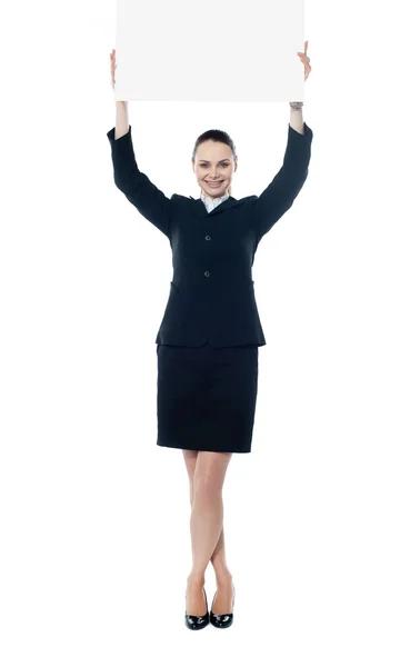 Young businesswoman holding a blank signboard — Stock Photo, Image