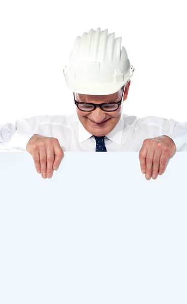 Constructor envejecido ganando y sosteniendo un cartel en blanco — Foto de Stock