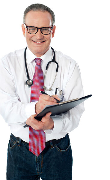 Happy smiling matured doctor writing on clipboard isolated against white background